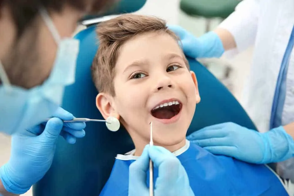 רופא שיניים מטפל בילד קטן