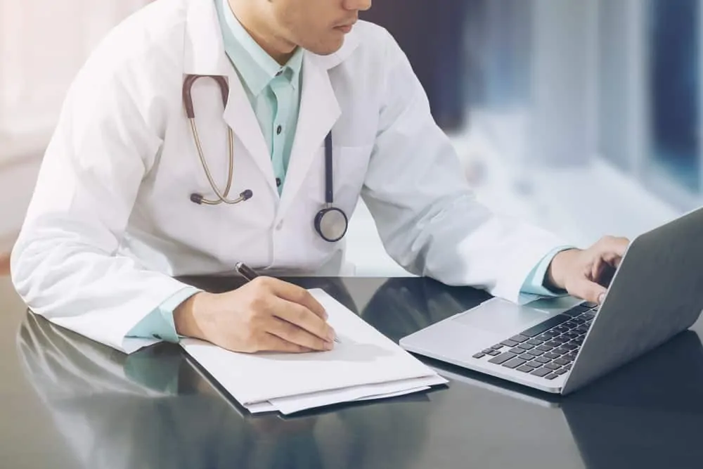 רופא מעתיק כתיבה תוכן מדף נייר למחשב נייד